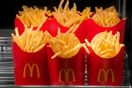 Duże frytki w czerwonych opakowaniach McDonald's. Zastanawiasz się, ile kosztują duże frytki w maku?